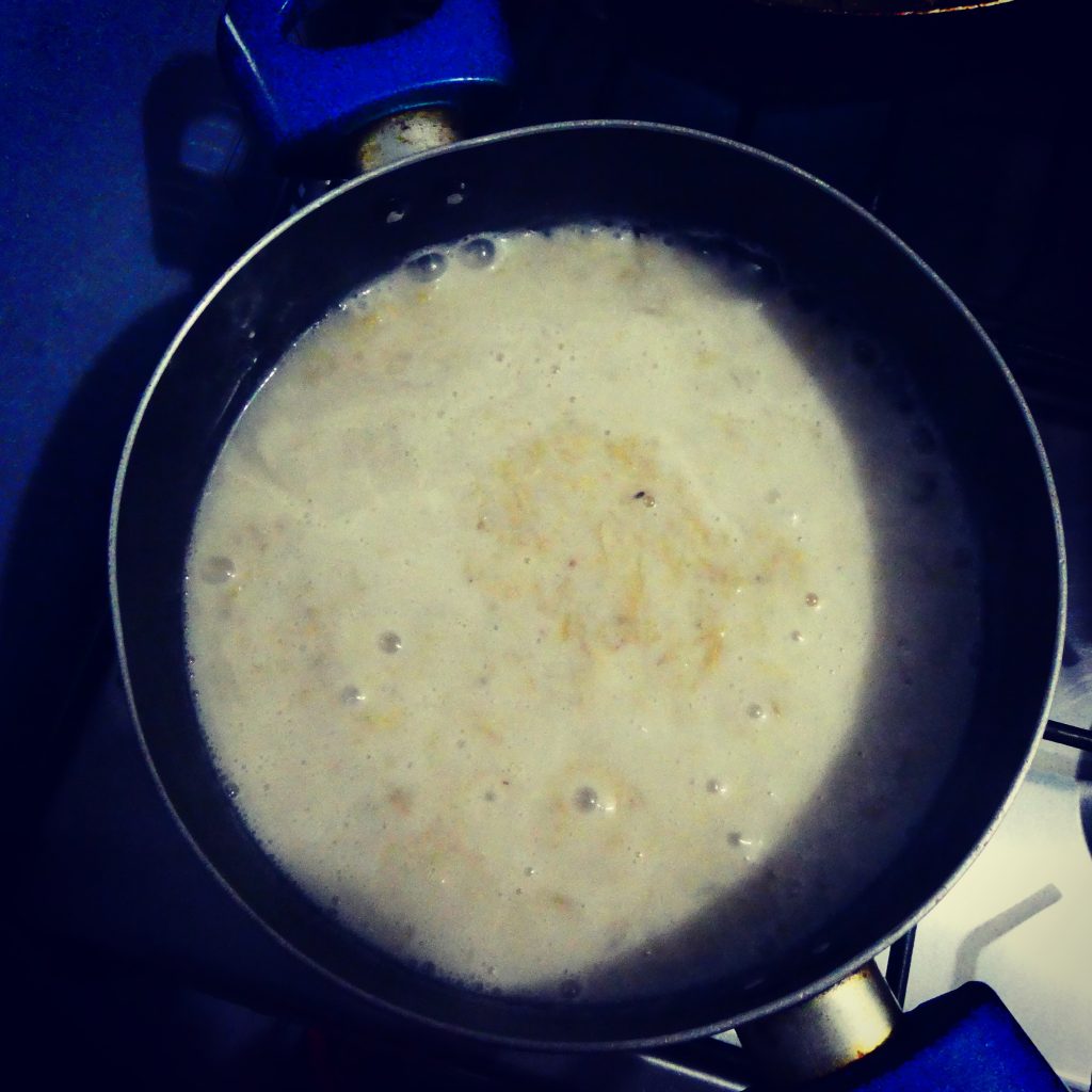 Cooking grated green plantain with milk and water