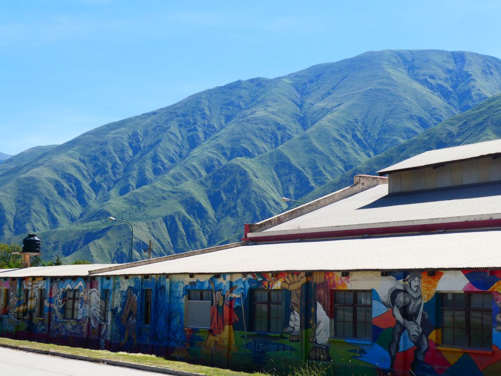street art on a building with mountain backdrop in the northwest of argentina