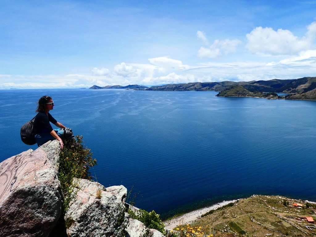 Anna seating on a rock overlooking Titicaca lake