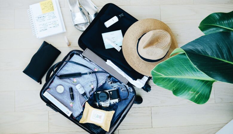 Packed suitcase with hat and camera for long-term travel