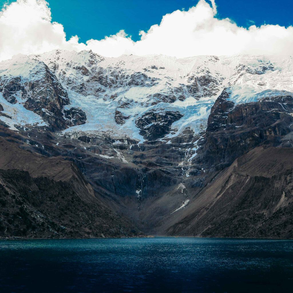 Beautiful mountain towering above Lake Humantay with a glacier waterfall