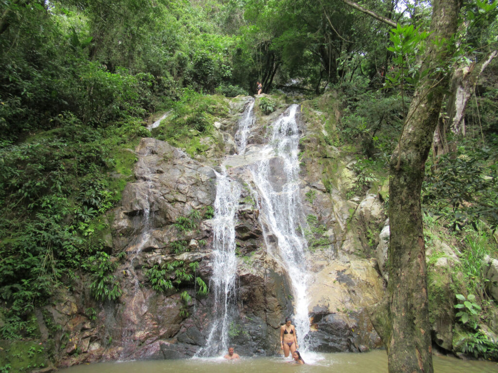 People bathing in the pool under Marinka Falls, Colombia